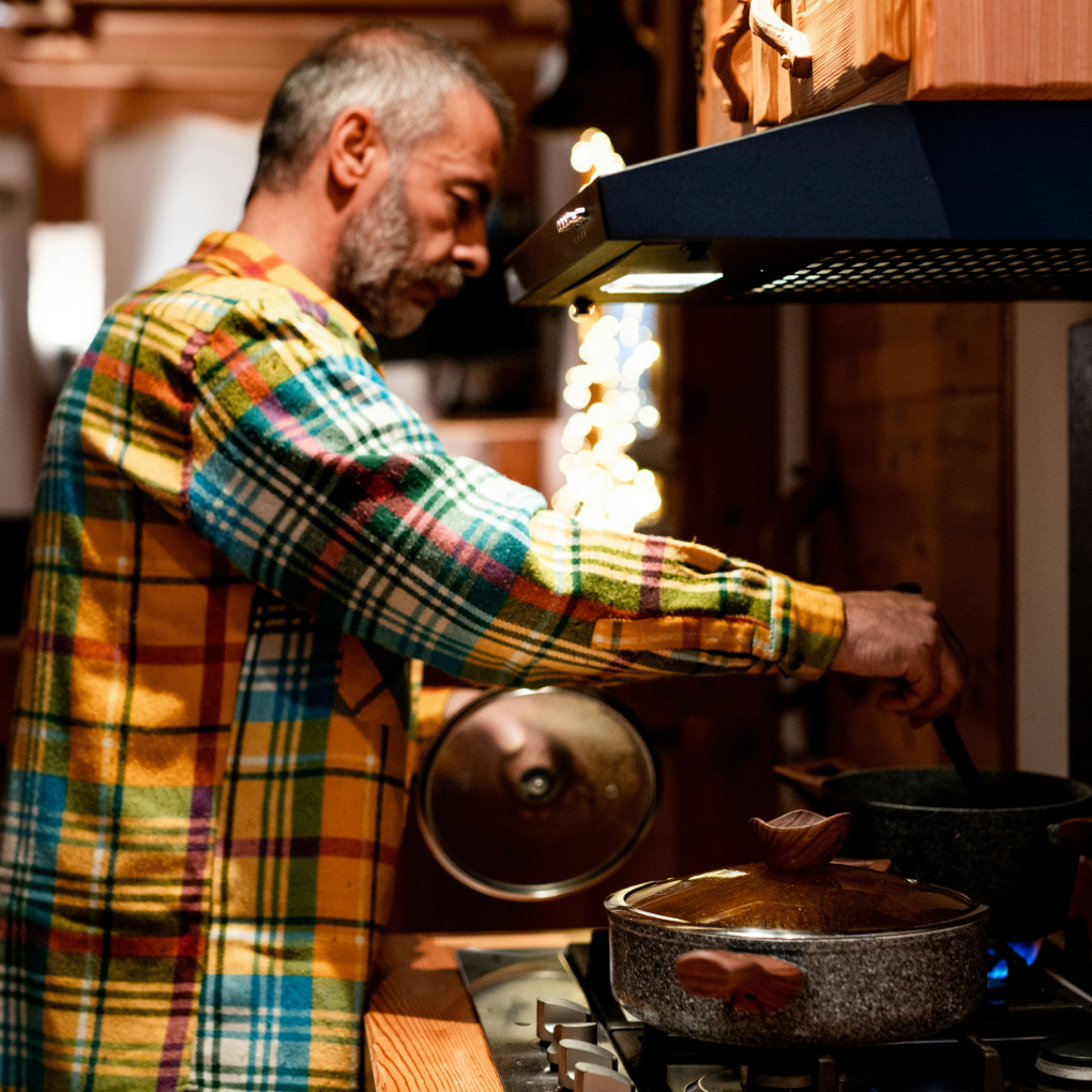 Man at stove cooking in kitchen