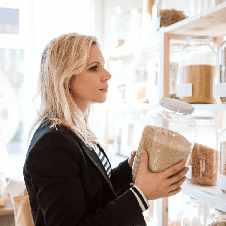 a woman holding a jar of grains at a zero waste store