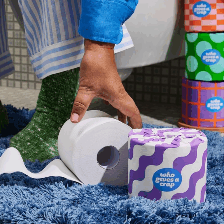 Person picking up a roll of chlorine-free toilet paper.