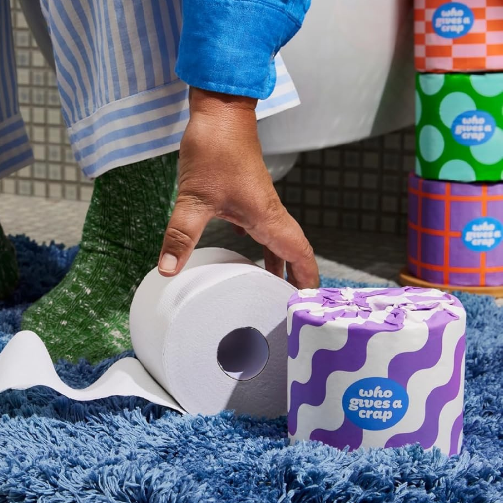 Person picking up a roll of chlorine-free toilet paper.