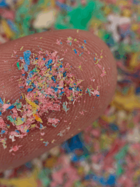 Colorful microplastics on the tip of the finger.