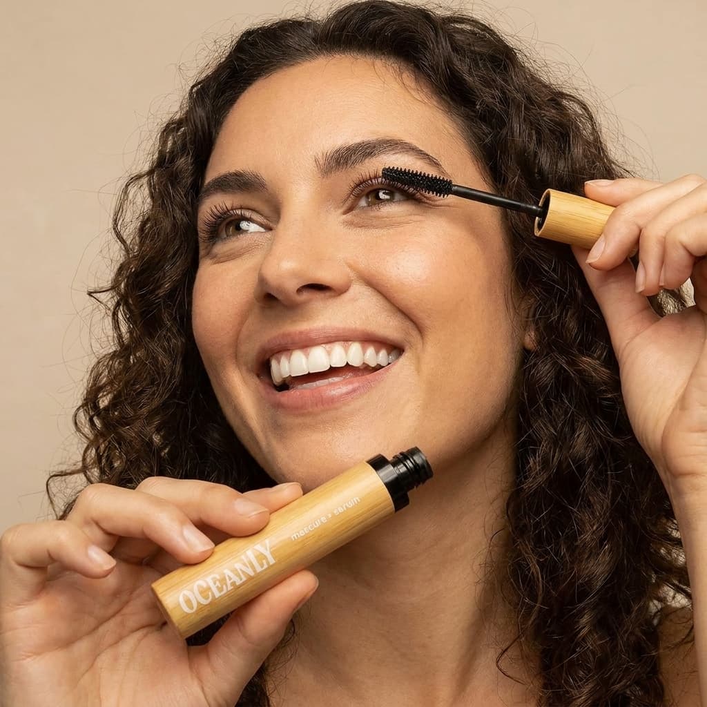 Girl with brown hair putting on Attitude mascara on.