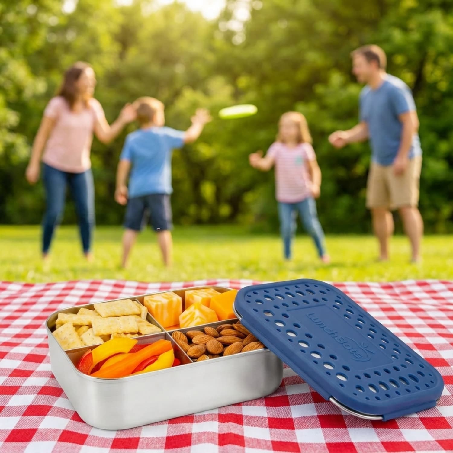 LunchBots stainless steel divided bento box on cream linen, plastic-free summer essentials for kids