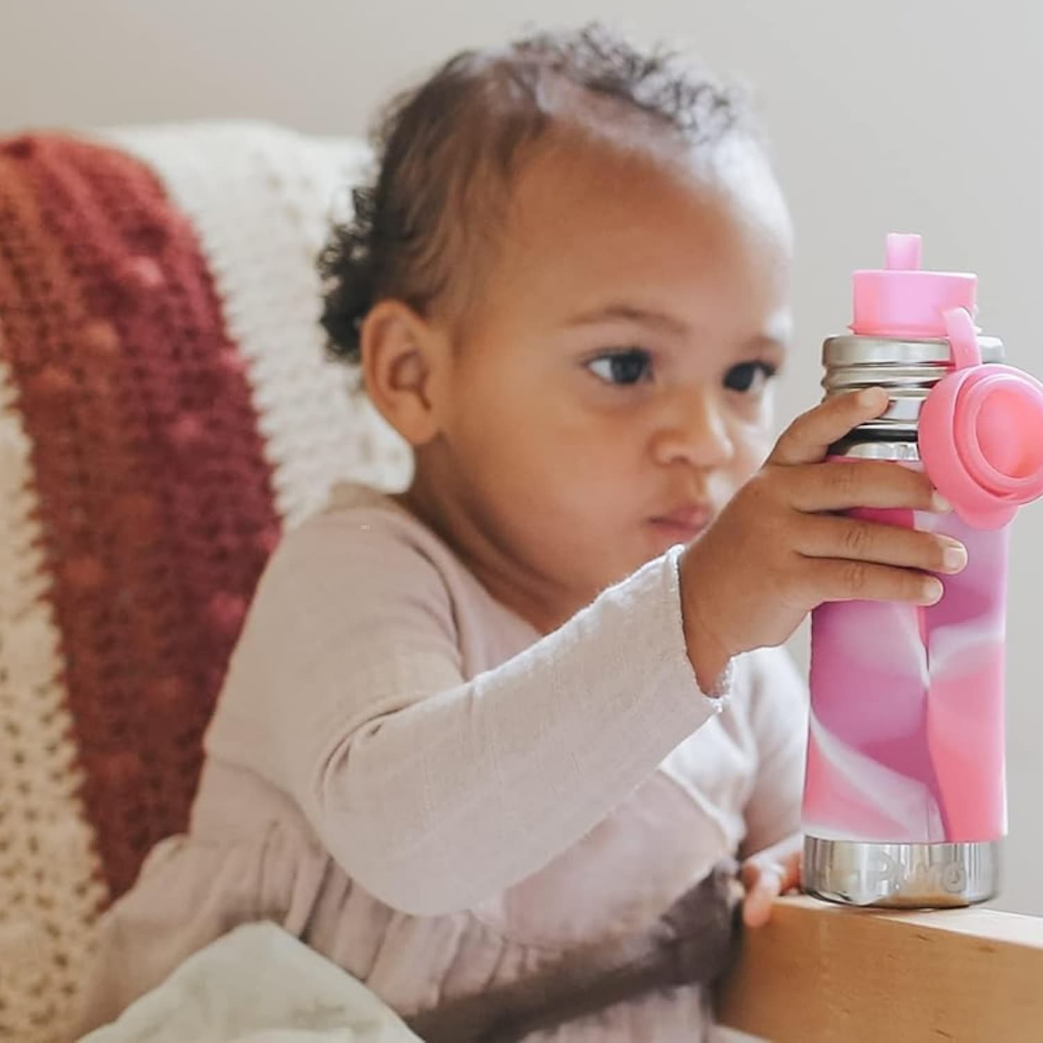 Pura Kiki stainless steel kids' bottle with silicone sleeve on natural linen, plastic-free summer essentials for kids