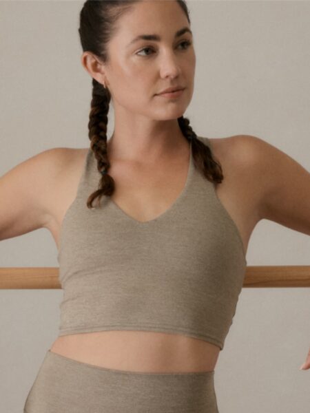 Woman leaning against the wall in athletic wear.