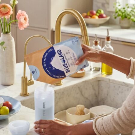 Woman pouring Blueland dishwashing powder into the forever bottle.