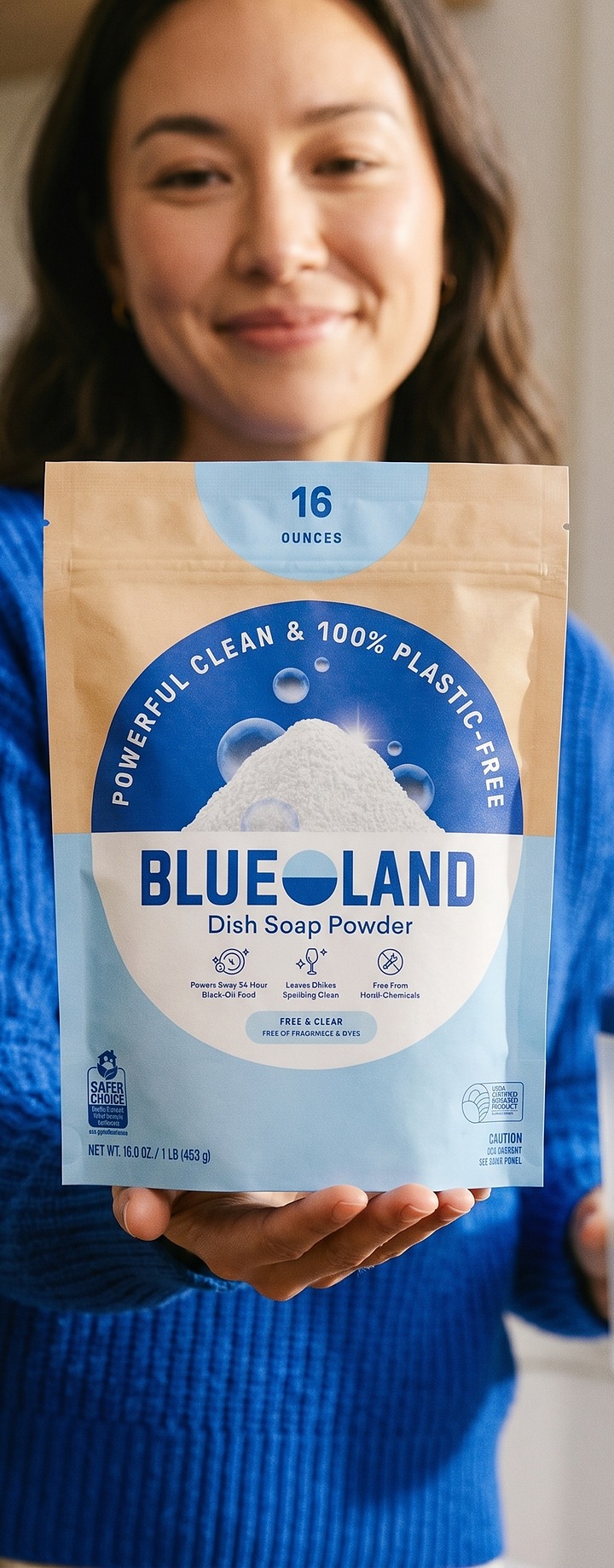 Woman holding a Blueland Dish Soap Powder refill pouch in her kitchen
