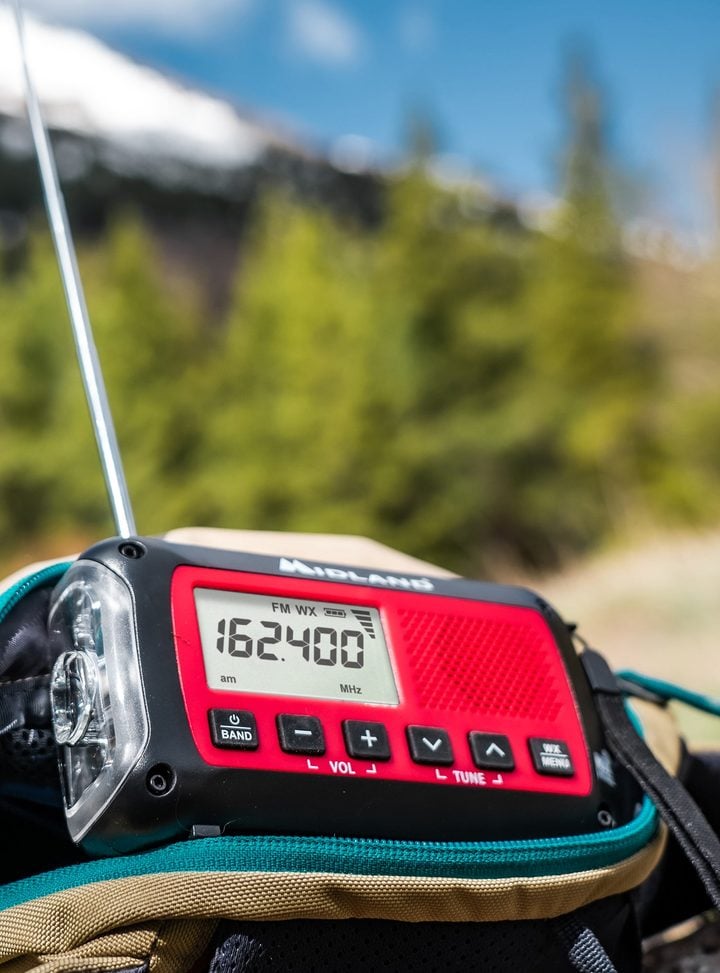 Midland ER40 emergency crank weather radio clipped to a backpack outdoors